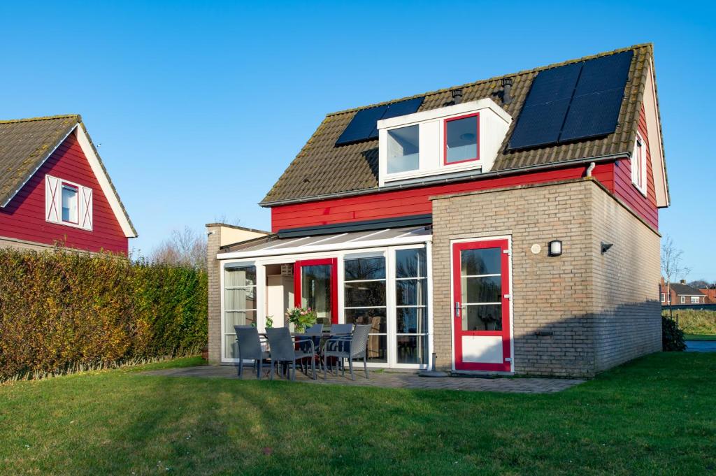 uma casa com painéis solares na lateral em Antibes 278 - Kustpark Village Scaldia em Hoofdplaat