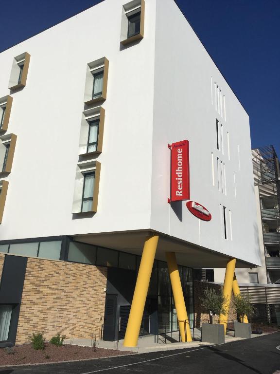a white building with a red sign on it at Residhome Toulouse Ponts Jumeaux in Toulouse