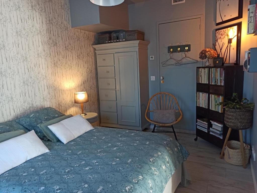 a bedroom with a bed and a chair and a book shelf at Loretxea in Sare