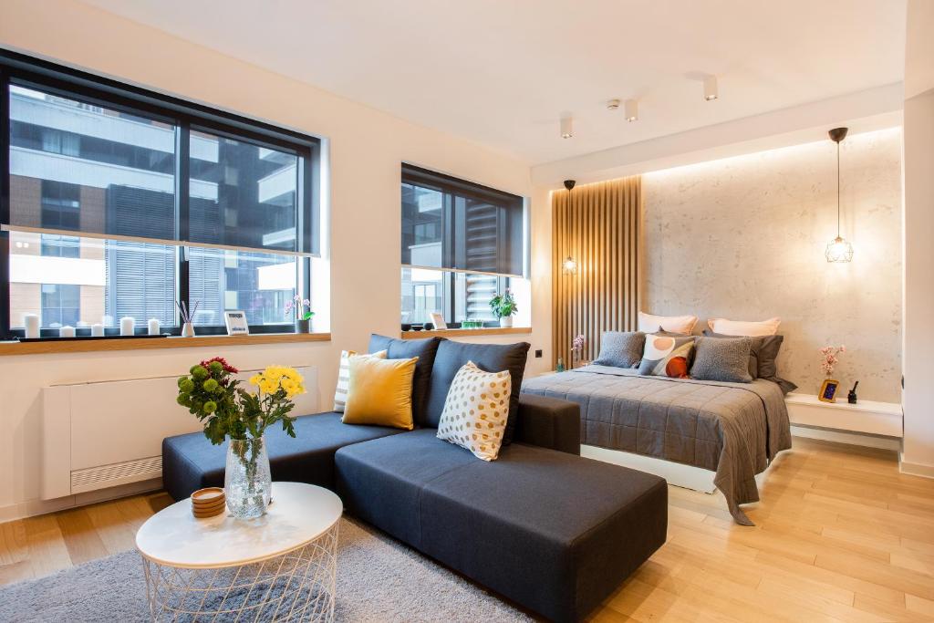 una camera con letto, divano e tavolo di Cozy LEO Apartment Free Garage, Wi-Fi, Concierge a Belgrado