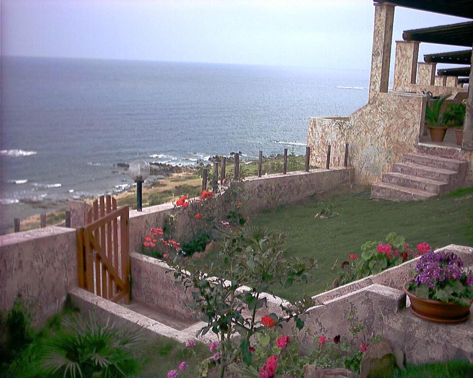 a view of the ocean from a house with flowers at VILLETTA SUL MARE, PANORAMICA in Villaputzu