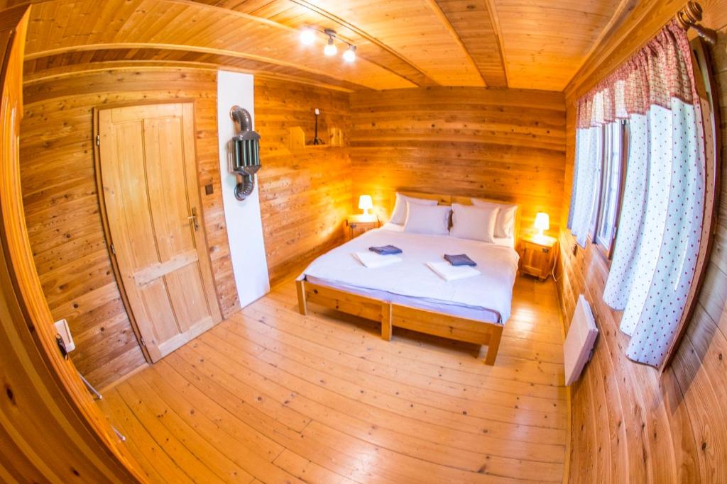 a bedroom with a bed in a wooden cabin at Elsa Chalupa in Kunvald