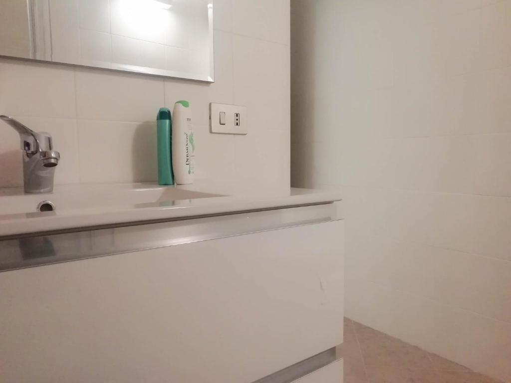 Biała kuchnia ze zlewem i kranem w obiekcie MistrangeloHome 5 - Appartamento in Pieno Centro w mieście Savona