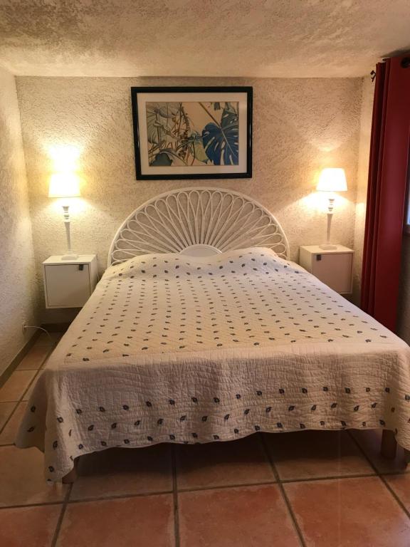 パトリモニオにあるAgréable Location au coeur du vignoble DOMINICI THERESEのベッドルーム1室(白いベッド1台、ランプ2つ付)