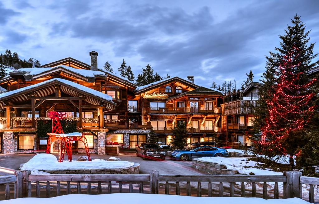 una grande casa con un albero di Natale davanti di Hôtel La Sivolière a Courchevel