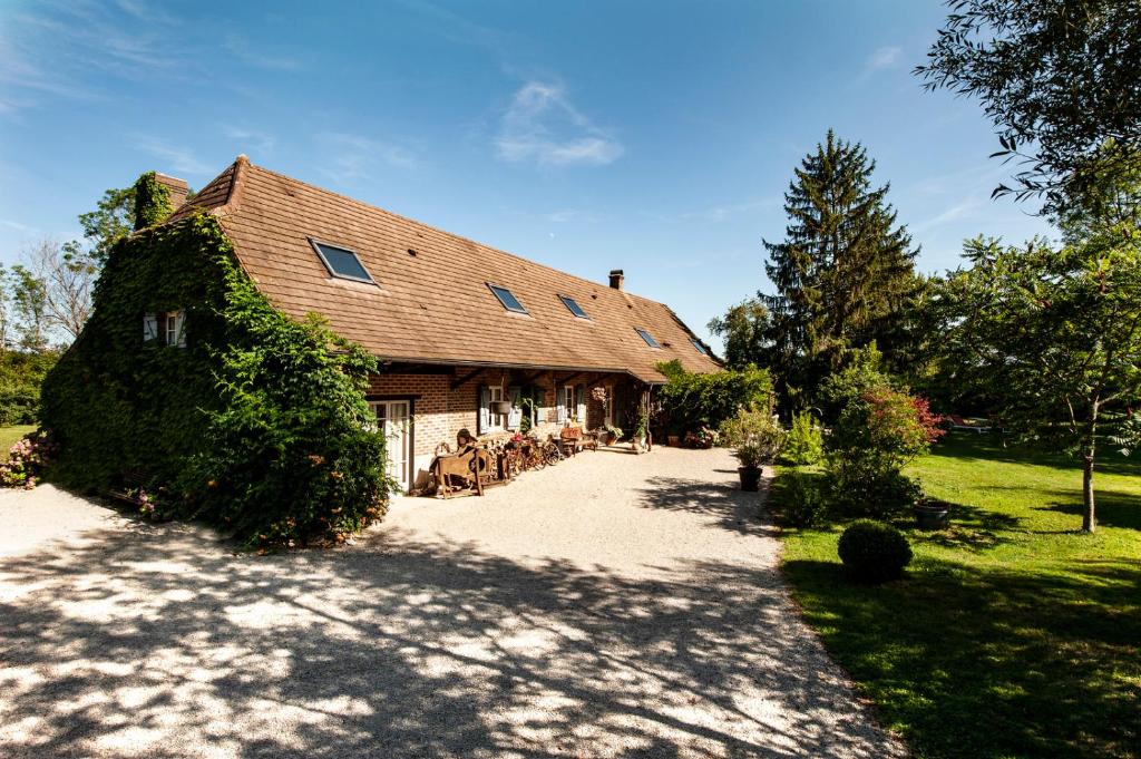 une grande maison avec des personnes assises à l'extérieur dans l'établissement Manoir-de-Sagy, à Sagy