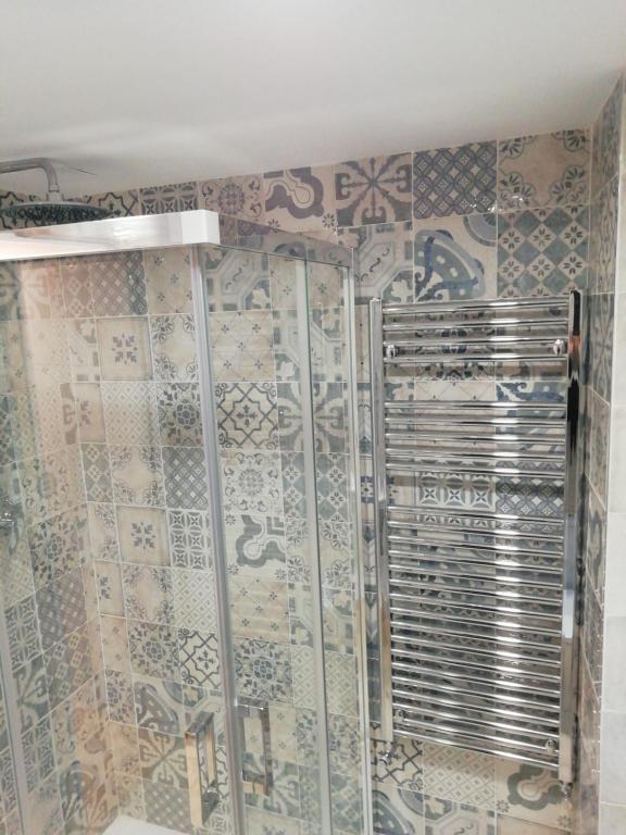 baño con ducha con mosaicos en la pared en Apartamento Turístico Santiago en Logroño