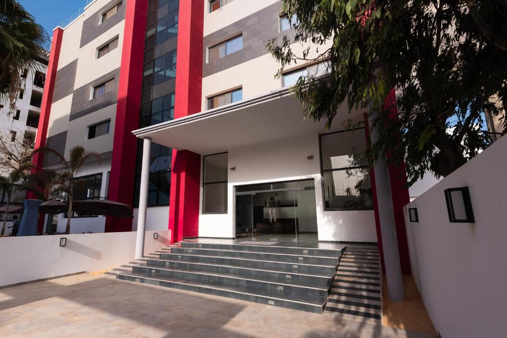 un bâtiment avec des escaliers en face de celui-ci dans l'établissement Hotel L'Adresse Dakar, à Dakar