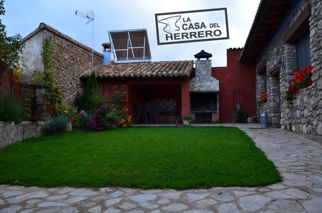 a house with a green lawn in front of it at La Casa del Herrero in El Poyo