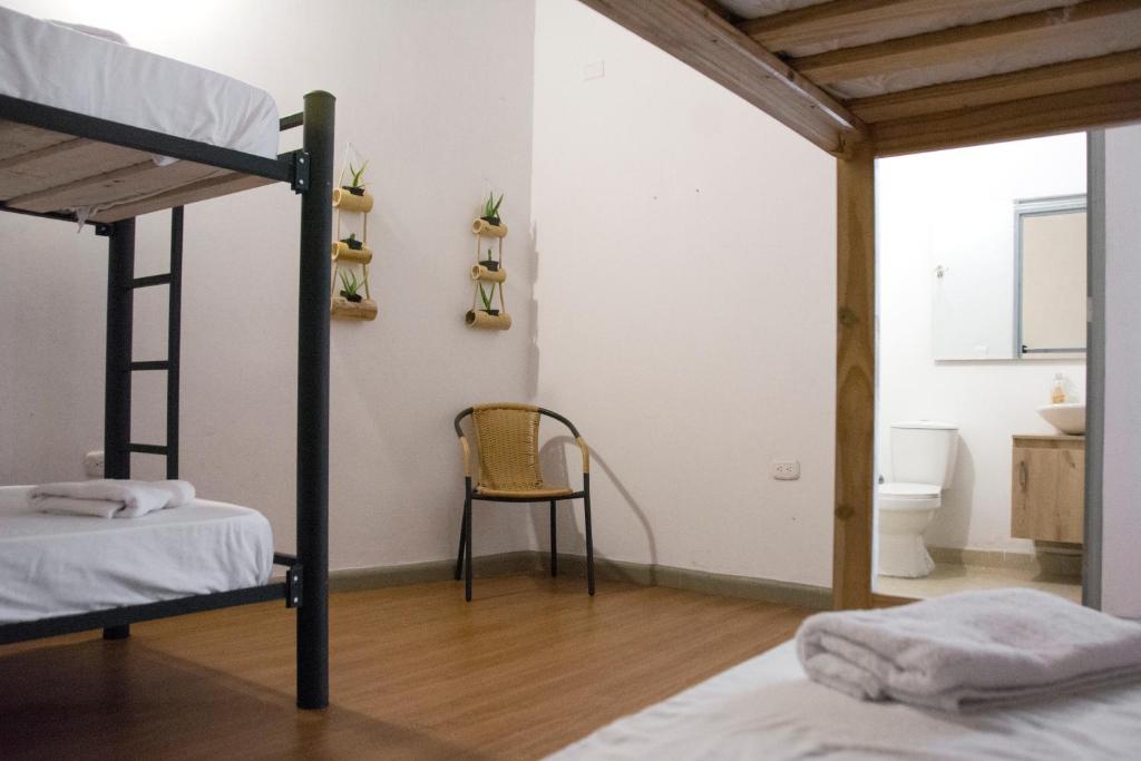 a bedroom with two bunk beds and a chair at La Vaina Cali in Cali