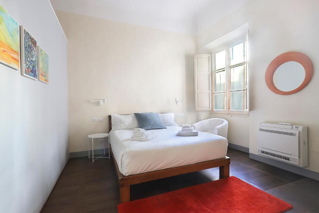 a small bedroom with a bed and a window at Apt. Perla - Pauline Suites, Palazzo Borghese in Florence
