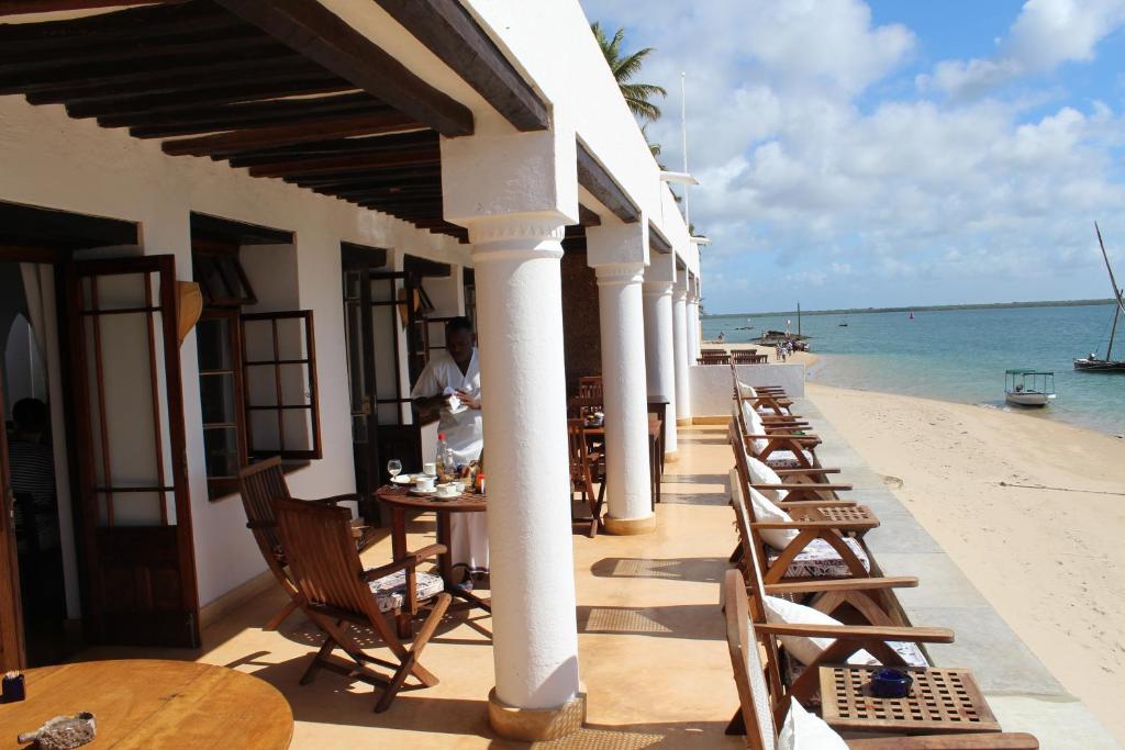 Shela的住宿－Peponi Hotel Lamu - Kenya，海滩上的餐厅,配有桌椅