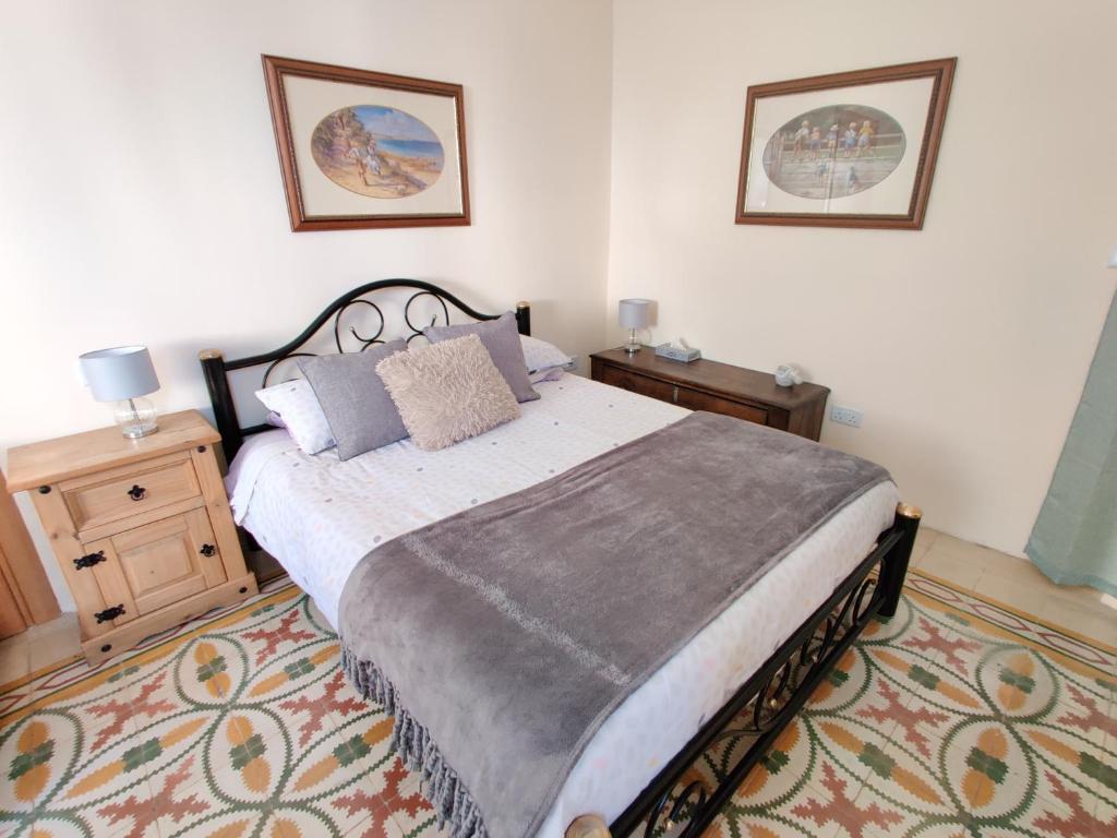 a bedroom with a large bed and a rug at Ellas Place in Tarxien