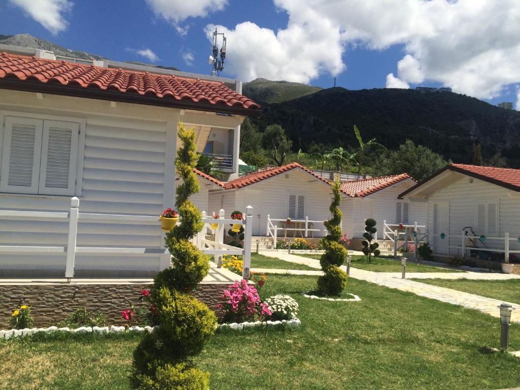 una casa con un jardín con flores en el patio en Vela e Bardhe, en Dhërmi