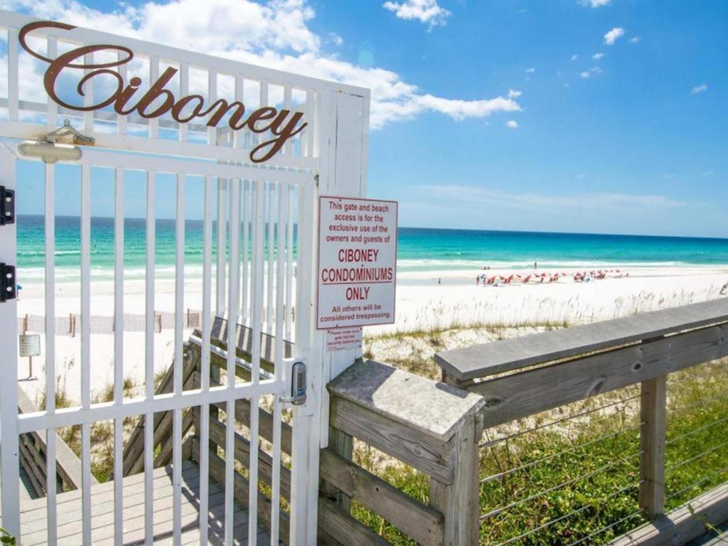 a gate at the beach with the ocean in the background at Ciboney Condominiums by Panhandle Getaways in Destin