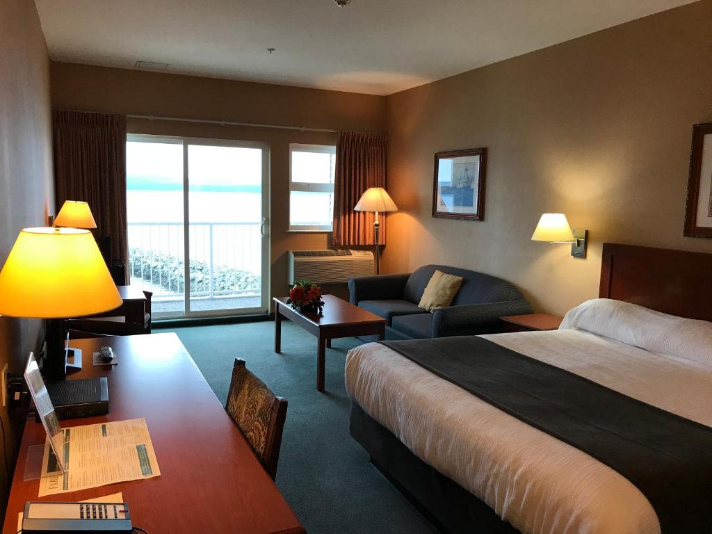 a hotel room with two beds and a television at Beach Gardens Resort and Marina in Powell River