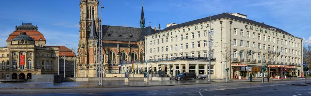 un gran edificio blanco con una torre de reloj en una calle en Hotel Chemnitzer Hof, en Chemnitz