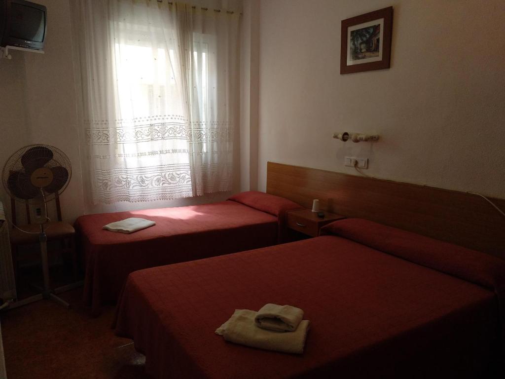 a hotel room with two beds and a window at PENSION MIRAFLORES in Zaragoza