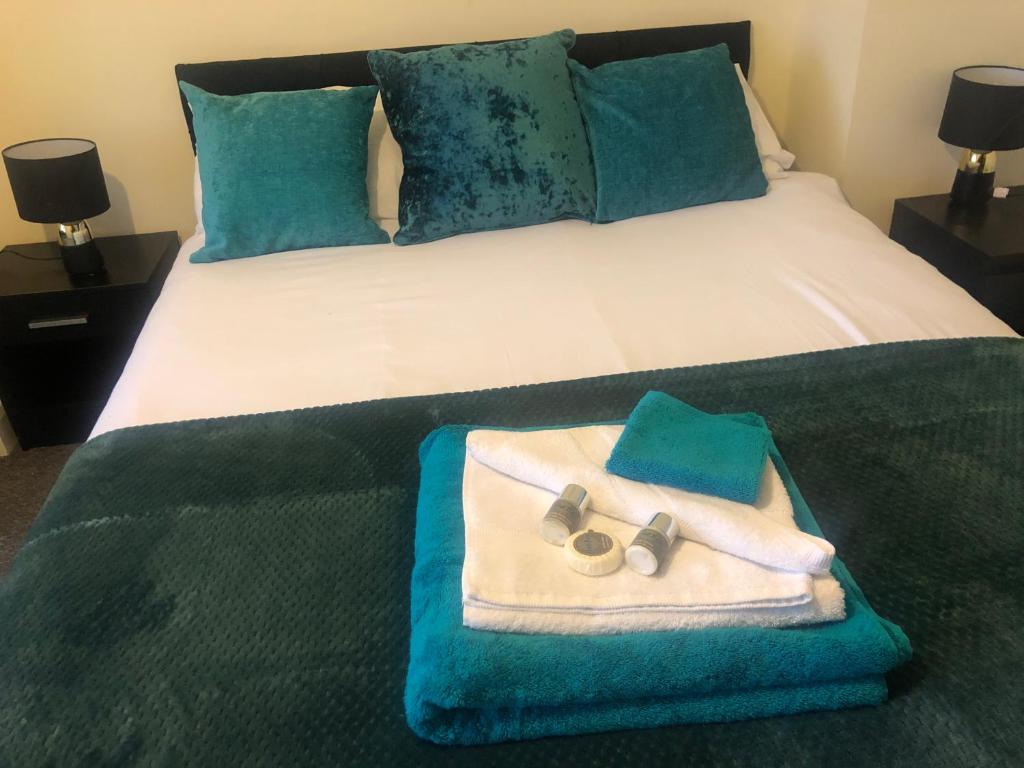 Una cama con una toalla y un par de zapatillas. en The Upper Room Apartment en Nottingham