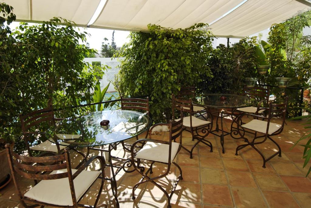 a patio with tables and chairs and plants at miKasa Agua Amarga & SPA in Agua Amarga