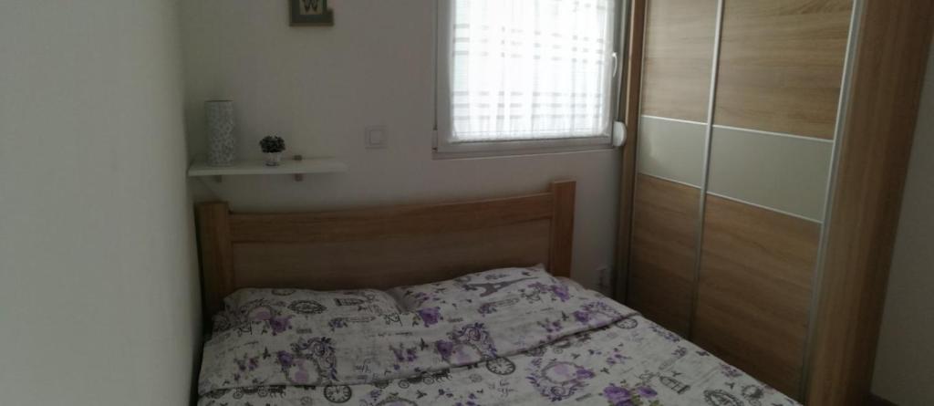 ein kleines Schlafzimmer mit einem Bett und einem Fenster in der Unterkunft Apartman Gušt in Herceg-Novi