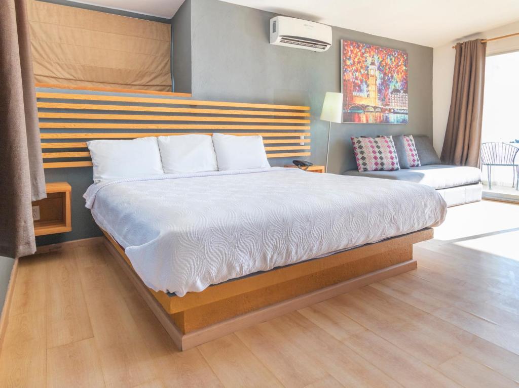 a bedroom with a large bed and a couch at Vf Hotel in Cuernavaca