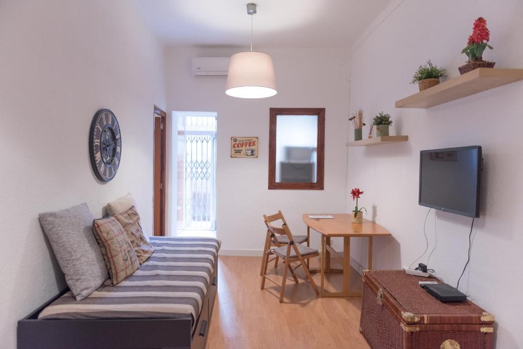 uma sala de estar com um sofá e uma mesa em Sweet BCN Studio with Terrace em Barcelona