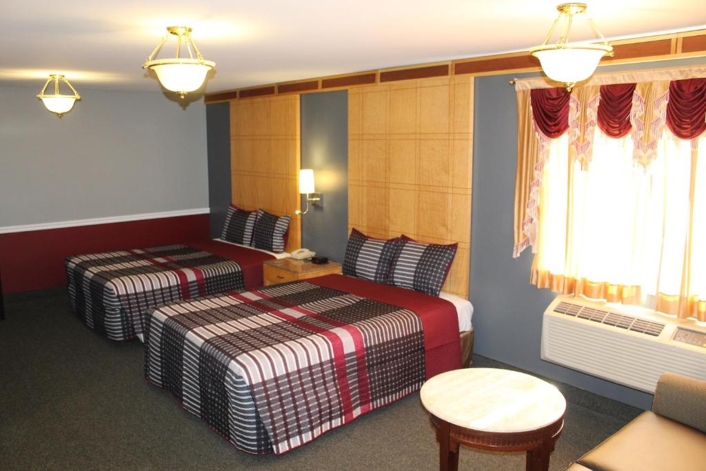 ein Hotelzimmer mit 2 Betten und einem Tisch in der Unterkunft Liberty Inn in Galloway