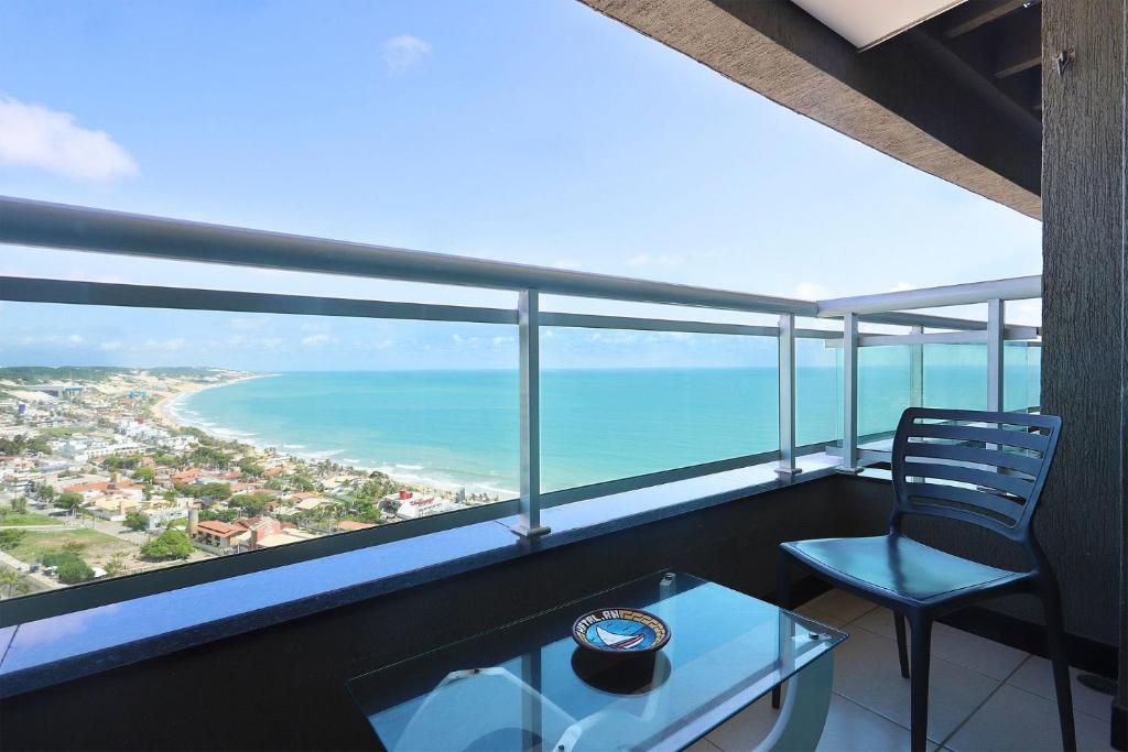 - un balcon avec une chaise et une table donnant sur l'océan dans l'établissement Duna Barcane, à Natal