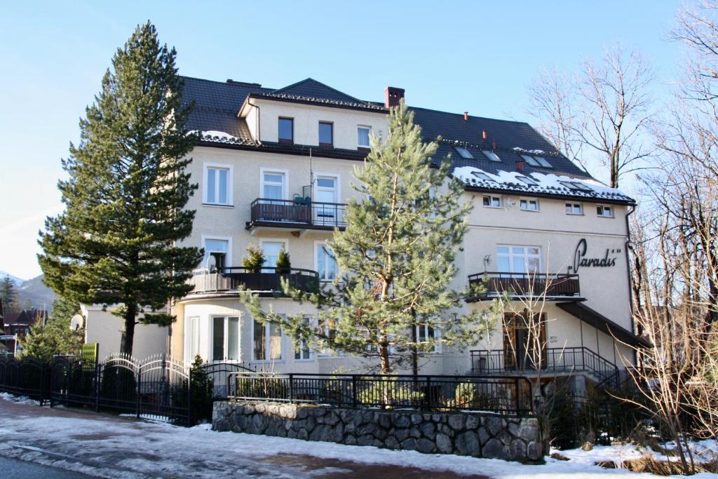 ein großes weißes Gebäude mit Bäumen davor in der Unterkunft Apartament Kasztanowy Centrum in Zakopane