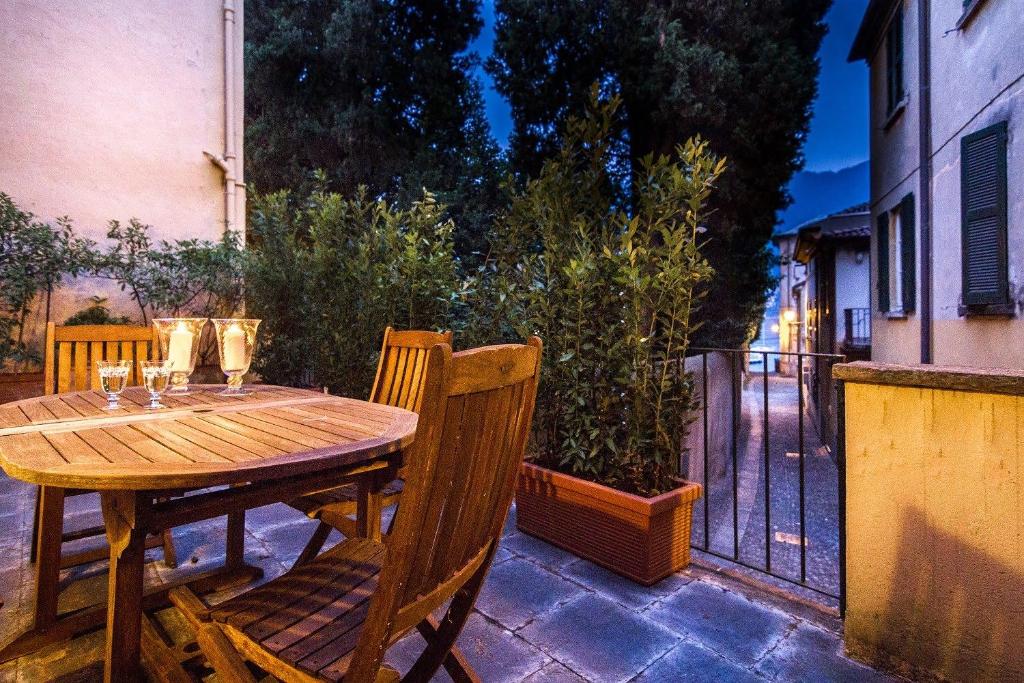 a wooden table and chairs on a patio at Cernobbio Town House in Cernobbio