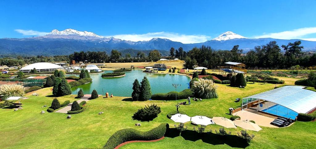 a resort with a lake and mountains in the background at Hacienda Panoaya in Amecameca de Juárez