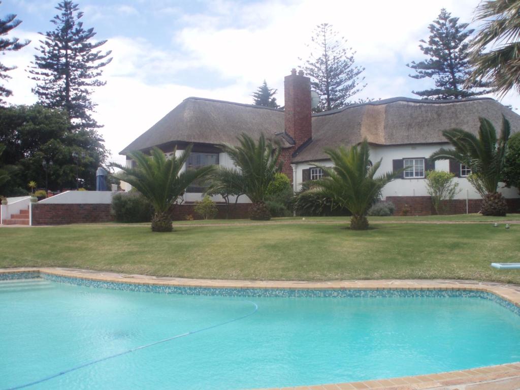 a house with a swimming pool in front of a house at The Sanctuary Guest House Estate in Cape Town