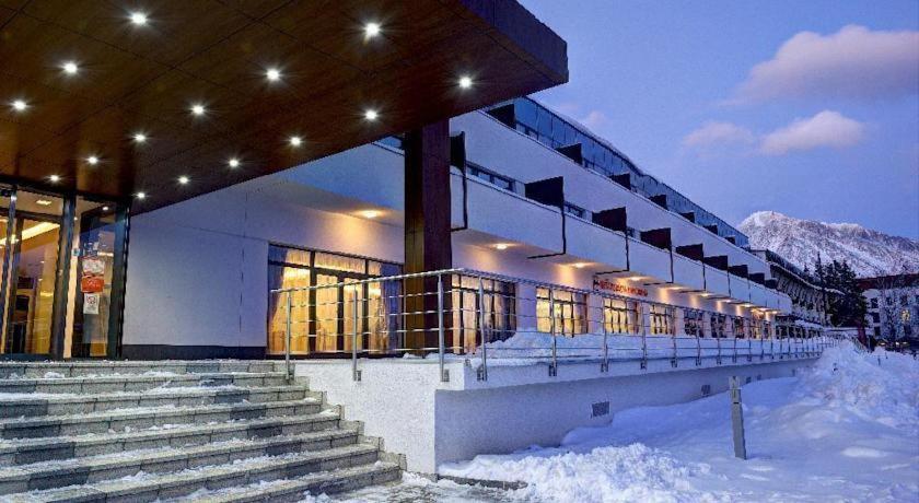 a building with stairs in the snow at night at Apartman Panorama 805 in Vysoke Tatry - Strbske Pleso