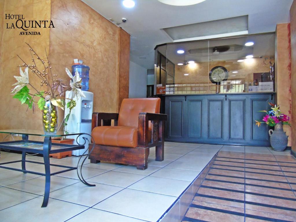 una sala de espera con una silla y una mesa en Hotel Quinta Avenida en San José
