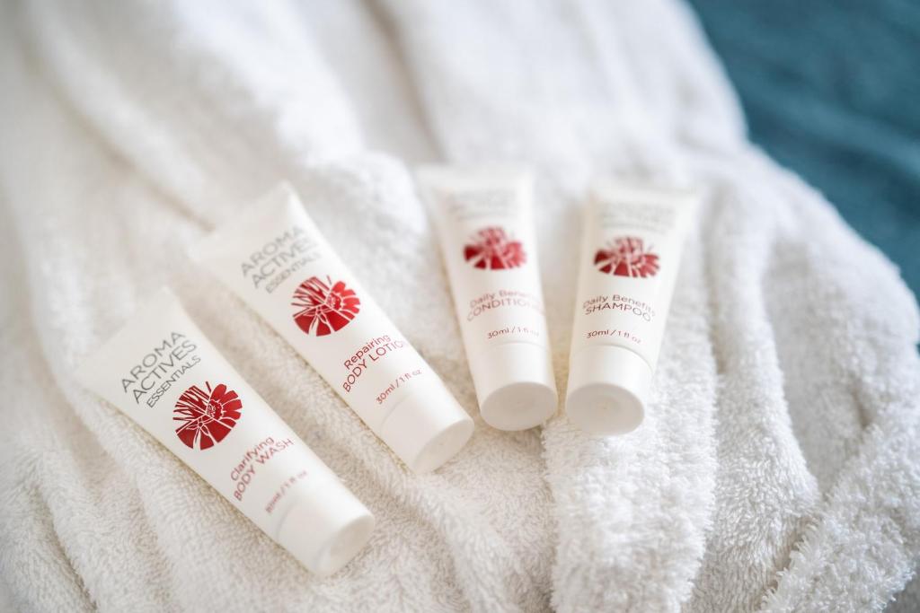 three tubes of sunscreen sitting on a white towel at Holiday Inn Bournemouth by IHG in Bournemouth