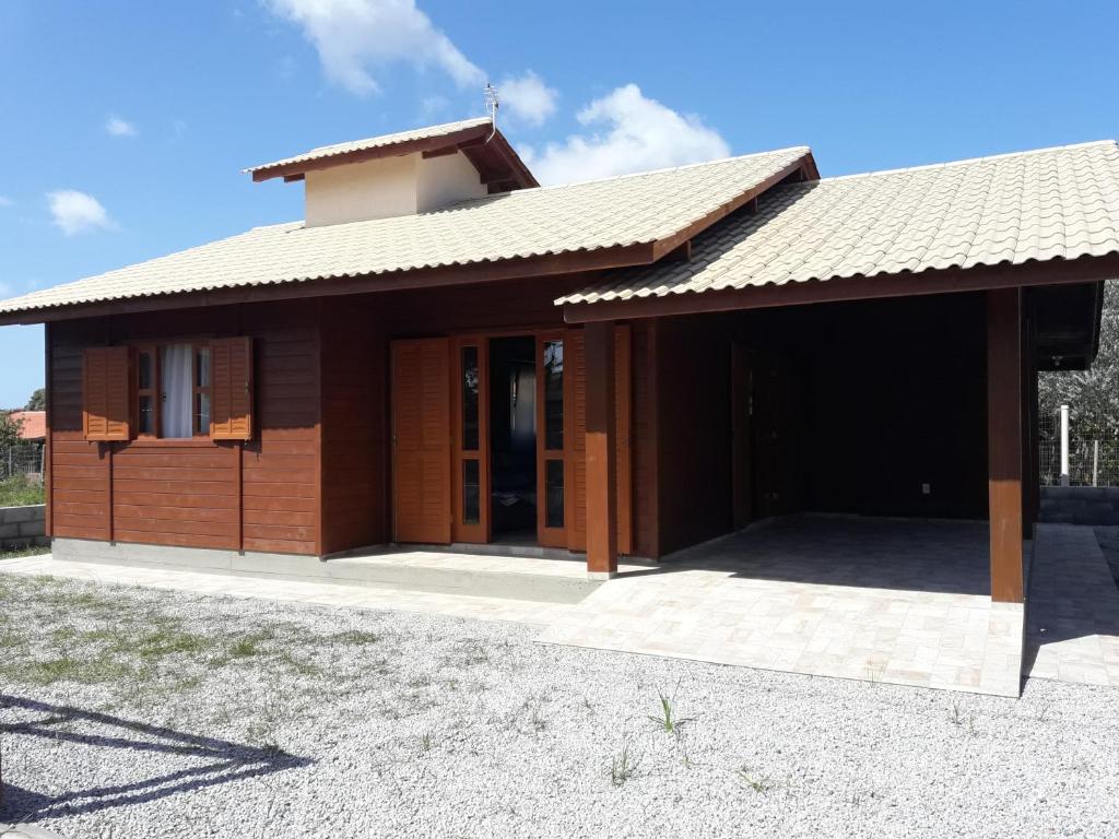 una pequeña casa con techo marrón en Casa Aconchegante Praia do Rosa Ibiraquera SC, en Imbituba