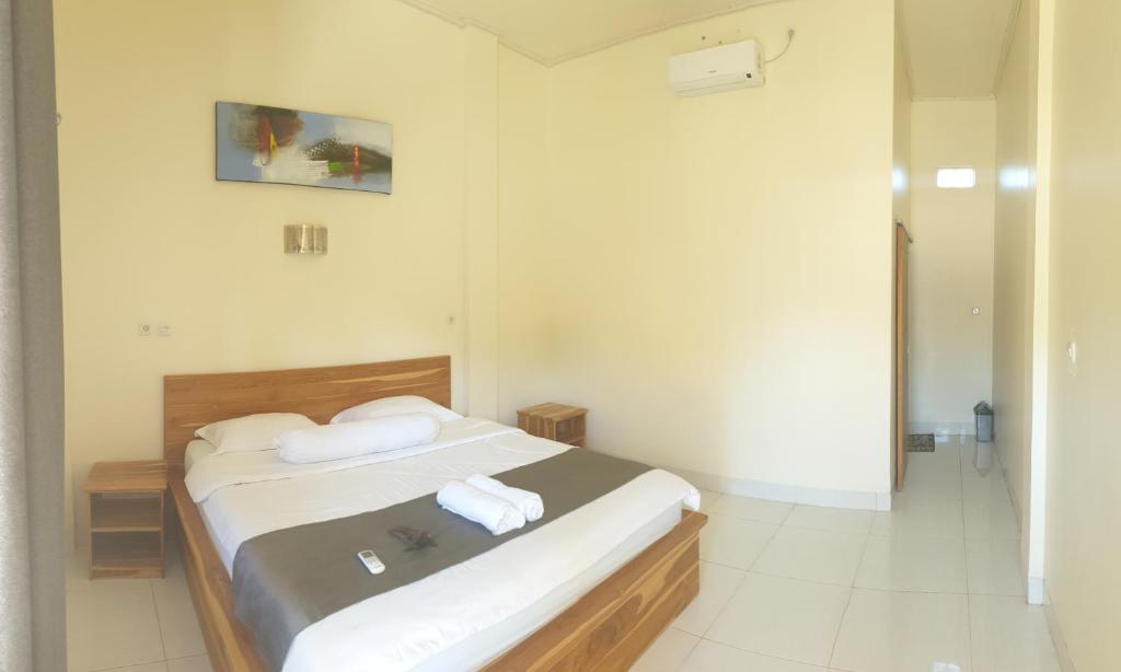 ein Schlafzimmer mit einem Bett mit zwei Handtüchern darauf in der Unterkunft Gio's Place in Labuan Bajo