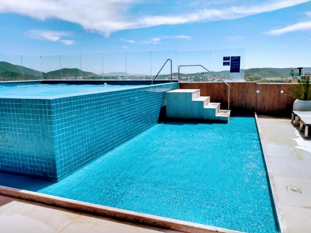 a swimming pool with blue tiles on a building at Flat em Cabo Frio in Cabo Frio