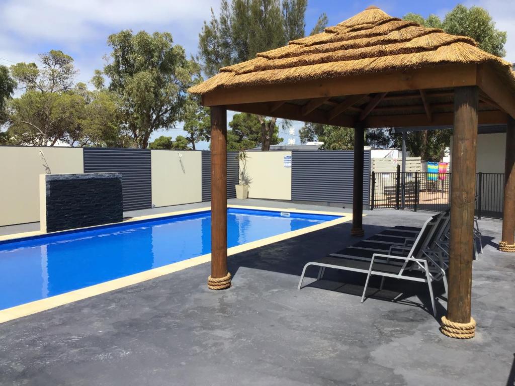 a chair under a pavilion next to a swimming pool at Ceduna Foreshore Caravan Park in Ceduna