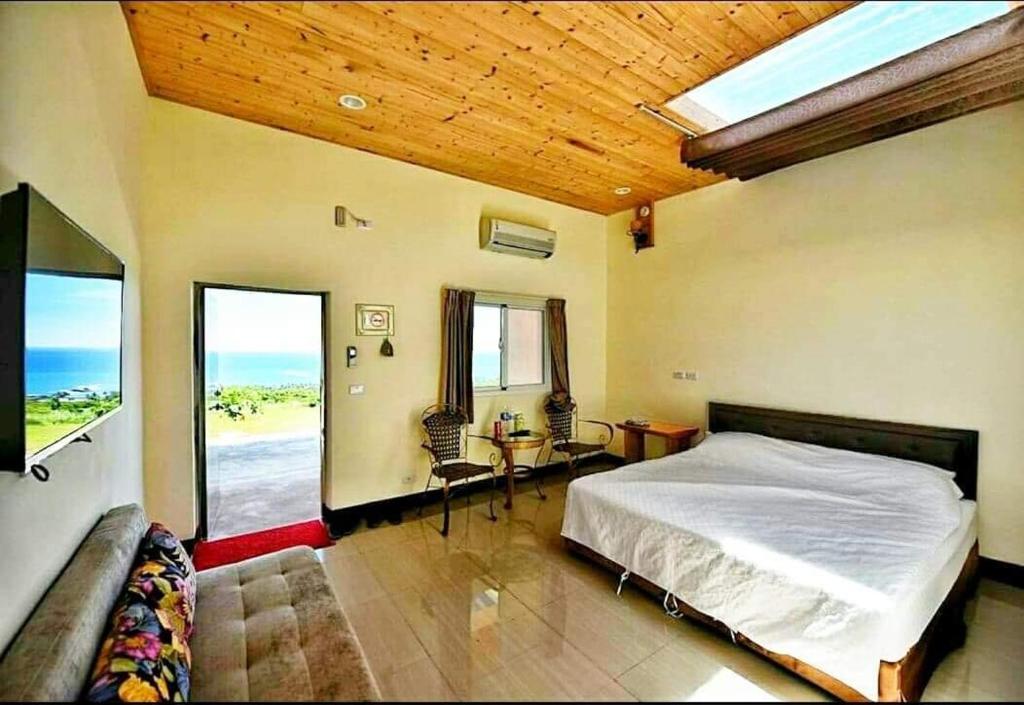 a bedroom with a bed and a view of the ocean at Taitung Sansiantai B&B in Chenggong
