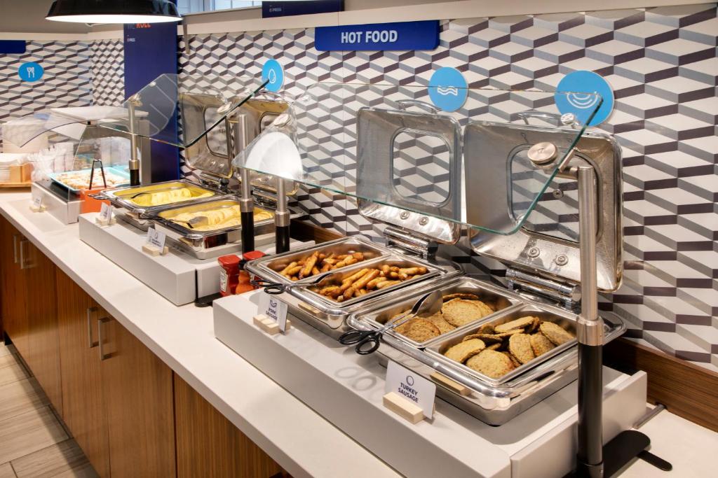a bakery counter with a bunch of pastries at Holiday Inn Express & Suites S Lake Buena Vista by IHG in Kissimmee