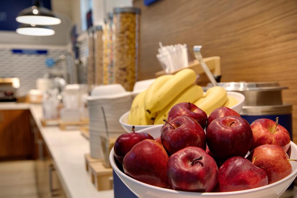 a bowl of apples and bananas on a counter at Holiday Inn Express & Suites S Lake Buena Vista by IHG in Kissimmee
