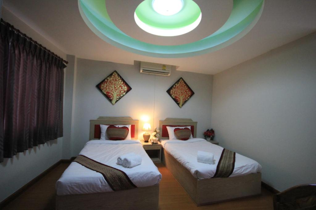 a room with two beds and a round ceiling at Home Place Hotel in Chiang Mai