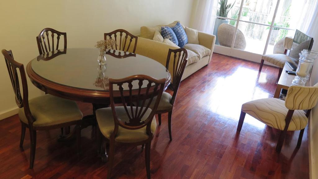 uma sala de estar com uma mesa e cadeiras e um sofá em Fabulous and Quiet Apartment+Balcony in Barrio Norte. Your easy access to Buenos Aires! em Buenos Aires