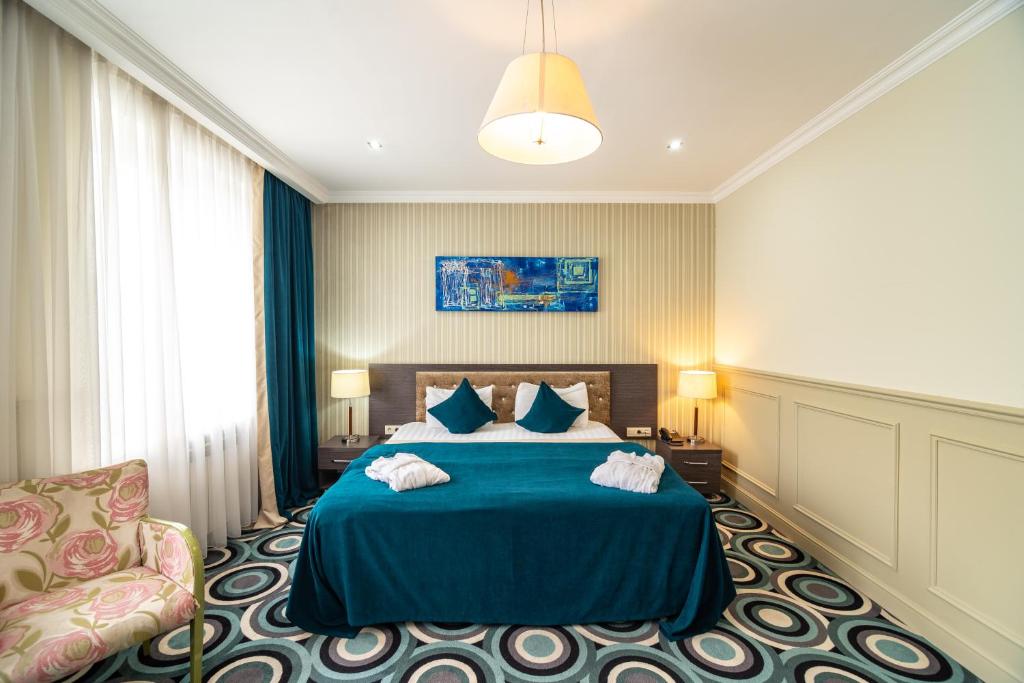阿拉木圖的住宿－Mildom Hotel，一间卧室配有蓝色的床和椅子
