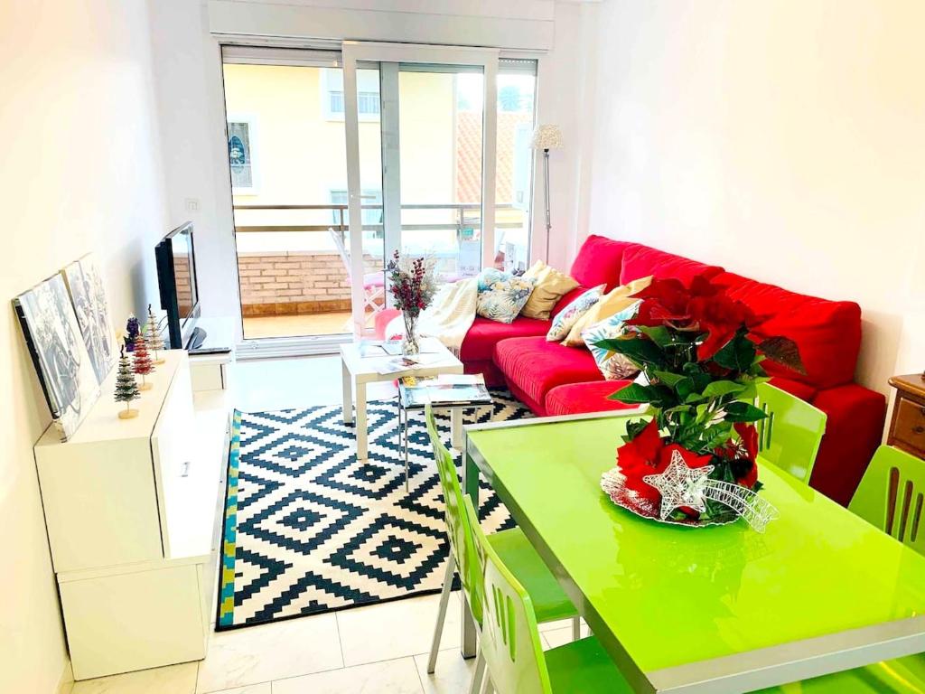a living room with a red couch and a green table at 2 bedrooms appartement at Santona 500 m away from the beach with balcony in Santoña