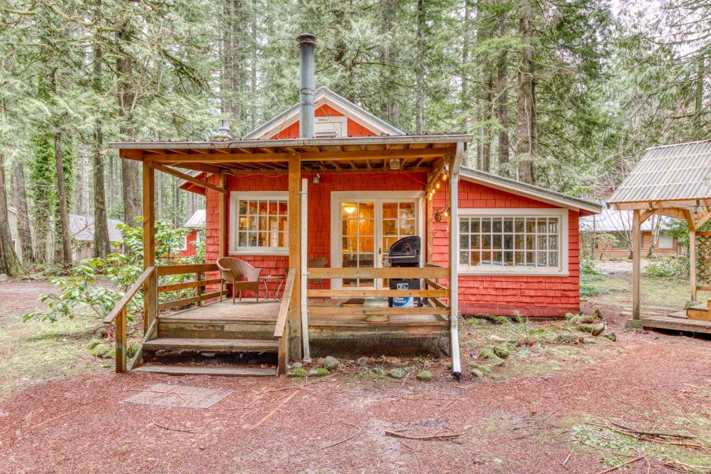 a red tiny house in the woods at The Cedars Cabin in Welches