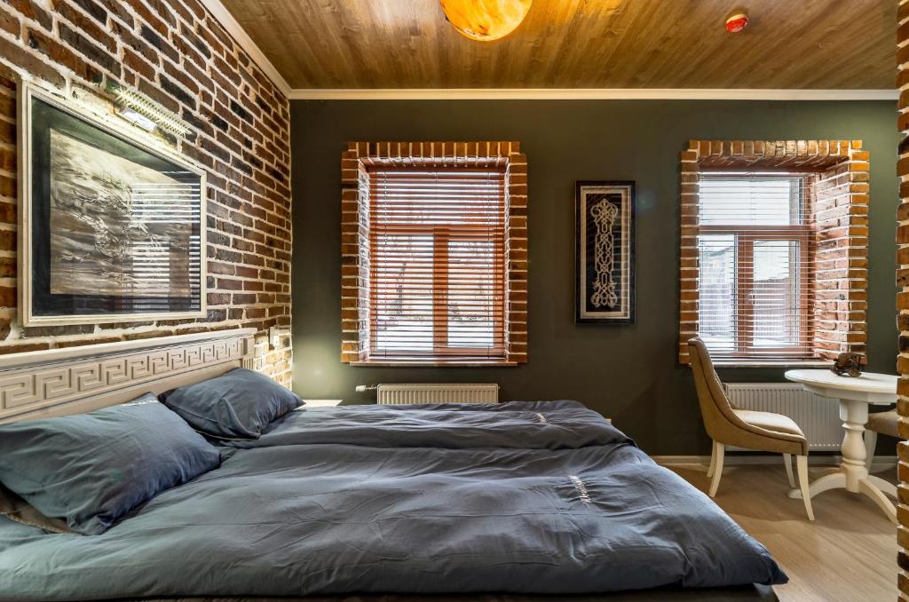 um quarto com uma cama e uma parede de tijolos em Hotel Family em Pskov