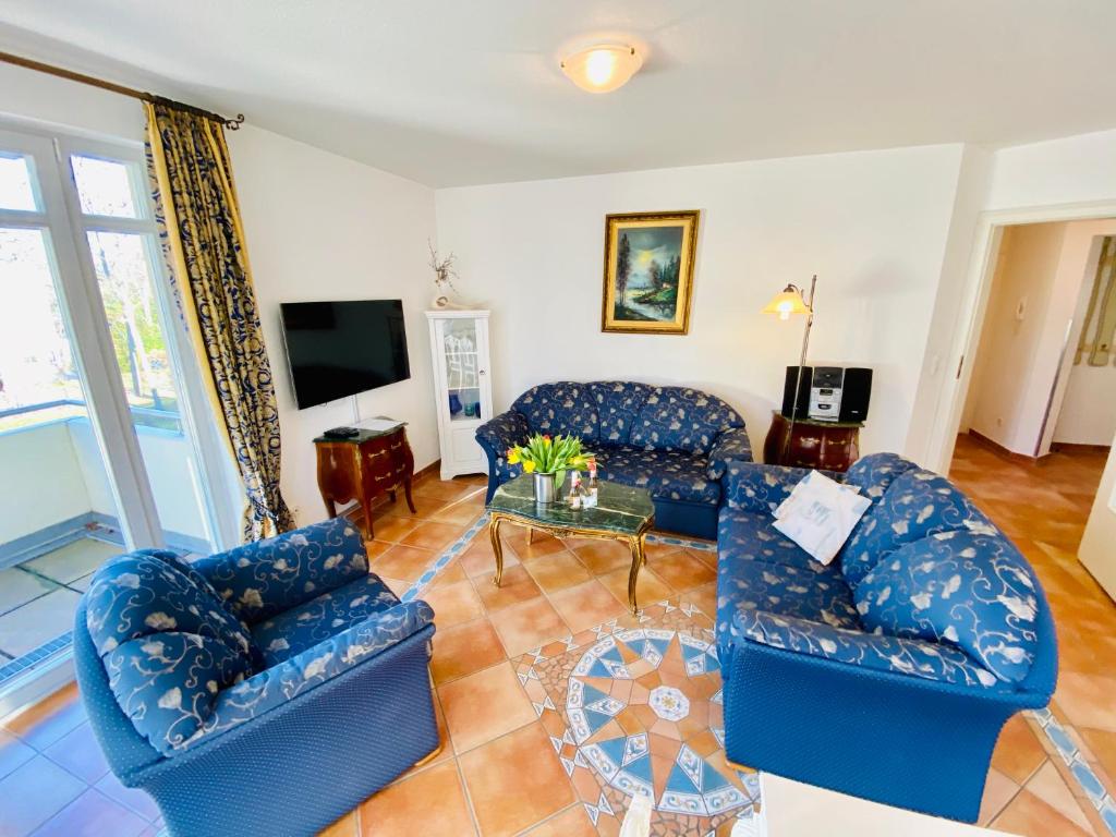 sala de estar con sofás azules y TV en Residenz Bleichröder - Ferienwohnung 18 en Heringsdorf
